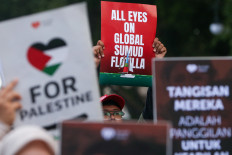 People carry placards on May 19, 2026, during a protest in solidarity with Indonesian nationals who were arrested aboard the Gaza-bound Global Sumud Flotilla, which was intercepted by Israeli forces in international waters, in Bandung, West Java. 