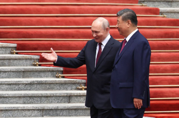  Russian President Vladimir Putin walks with Chinese President Xi Jinping during a welcoming ceremony at the Great Hall of the People in Beijing, China May 20, 2026. 