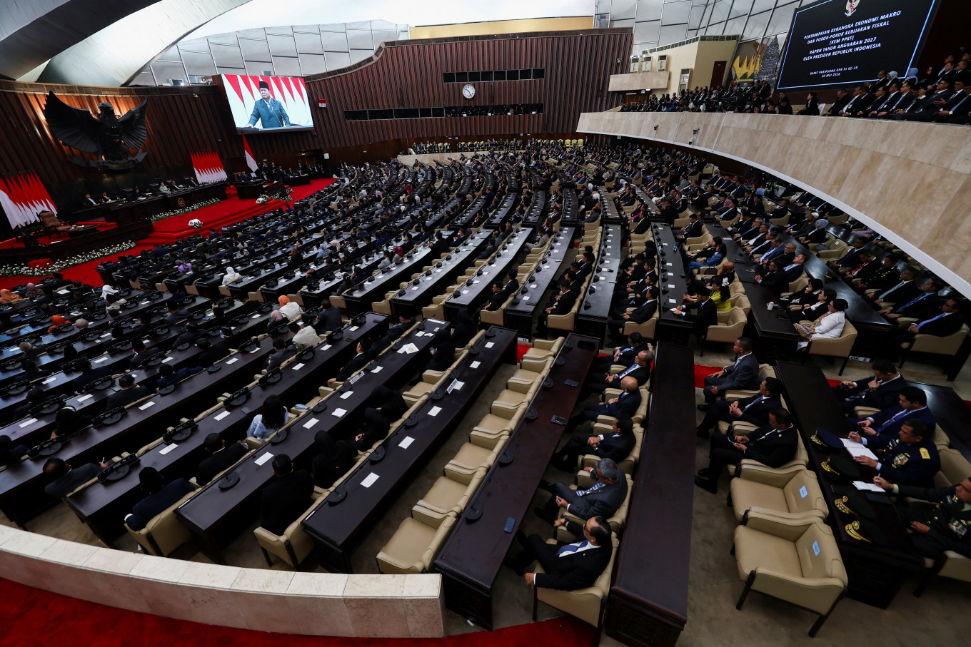 A large screen displays President Prabowo Subianto as he delivers his speech on economic policies and the 2027 fiscal plan House of Representatives members at the Senayan Legislative Complex in Central Jakarta on May 20, 2026. 