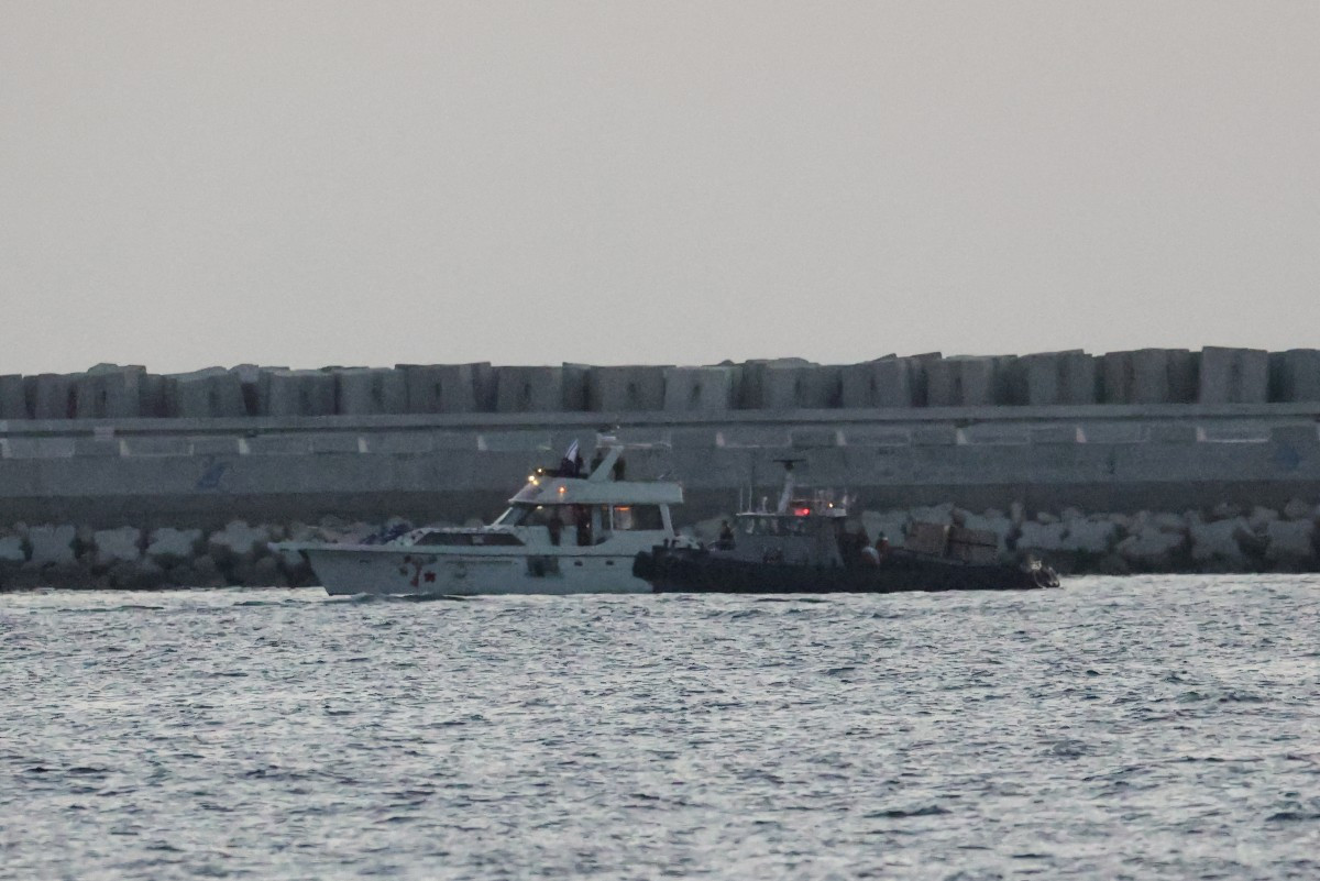 A boat bearing symbols of one of the vessels belonging to the Gaza-bound aid flotilla (left) and intercepted by the Israeli navy, is motored towards the Israeli port of Ashdod, about 40 kilometers south of Tel Aviv, on May 19, 2026.