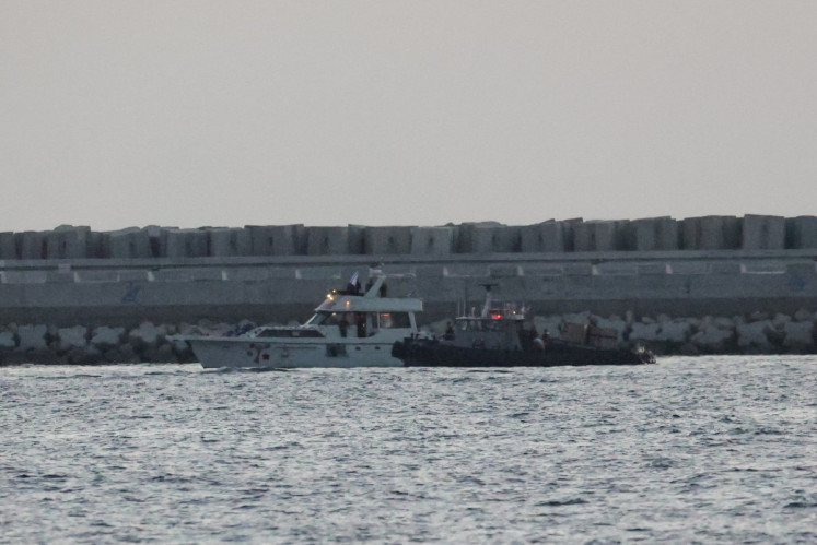 A boat bearing symbols of one of the vessels belonging to the Gaza-bound aid flotilla (left) and intercepted by the Israeli navy, is motored towards the Israeli port of Ashdod, about 40 kilometers south of Tel Aviv, on May 19, 2026.