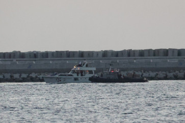 A boat bearing symbols of one of the vessels belonging to the Gaza-bound aid flotilla (left) and intercepted by the Israeli navy, is motored towards the Israeli port of Ashdod, about 40 kilometers south of Tel Aviv, on May 19, 2026.