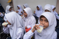 Students drink milk as they eat lunch on Jan 6, 2025, the first day of the free nutritious meal program, at SMPN 12 Cimahi state junior high school in Cimahi, West Java.