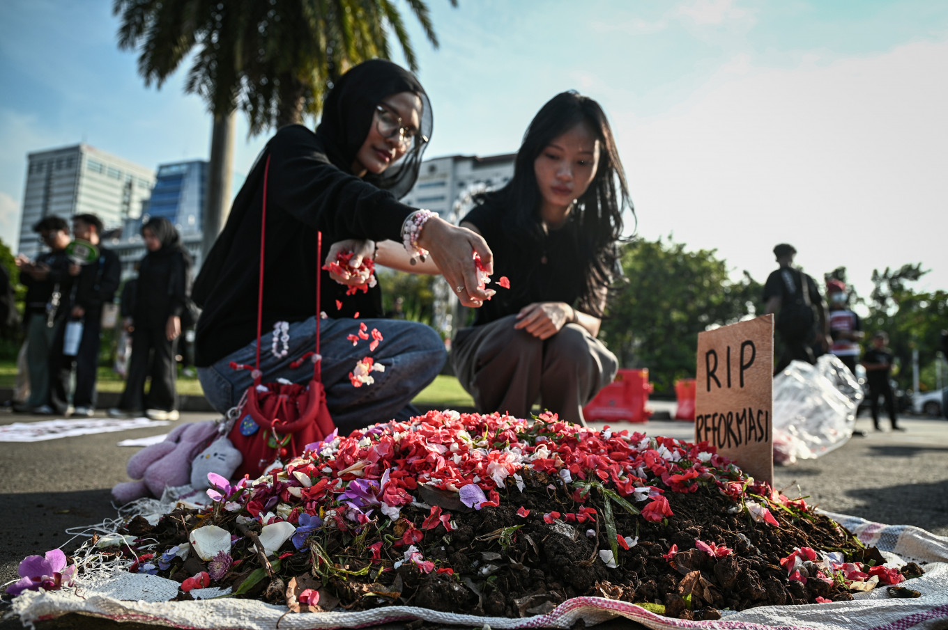 Human rights activists grouped under the Solidarity Network of Victims for Justice scatter flower petals on May 21, 2026, during the 908th Kamisan (Thursdays) protest across from the Merdeka Palace in Jakarta. The rally called for the resolution of unresolved human rights abuse cases while commemorating the 28th anniversary of the May 1998 Reform Era movement that toppled the New Order regime.