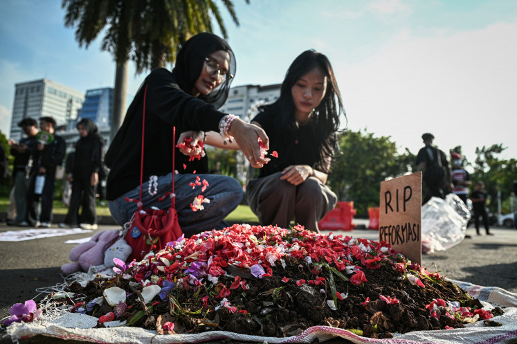 Human rights activists grouped under the Solidarity Network of Victims for Justice scatter flower petals on May 21, 2026, during the 908th Kamisan (Thursdays) protest across from the Merdeka Palace in Jakarta. The rally called for the resolution of unresolved human rights abuse cases while commemorating the 28th anniversary of the May 1998 Reform Era movement that toppled the New Order regime.