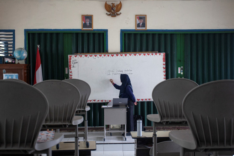 An elementary school teacher teaches her pupils online due to worsening air quality caused by forest fires in Palembang, South Sumatra, on Oct. 5, 2023.