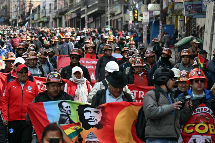 Miners, factory workers and Indigenous people from the 'Ponchos Rojos' union take part in a march calling for the resignation of Bolivian President Rodrigo Paz in La Paz on May 22, 2026. Thousands of demonstrators demanded the resignation of centre-right President Paz in Bolivia's political capital during a new day of protests that led to clashes with riot police.