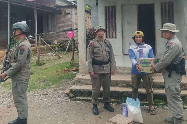 Human connection: Local members of Operation Madago Raya, a deradicalization and counterterrorism public security initiative run jointly by the National Police and the Indonesian Military, provides basic staples to a former terrorist (second right) on Nov. 3, 2025, during a social assistance handover event in Poso, Central Sulawesi.