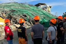 This handout photo taken and released on May 24, 2026 via the Facebook page of the Angeles City Public Information Office shows rescuers standing next to a collapsed building in Angeles City in Pampanga province. Nineteen people are feared trapped after a building under construction near Manila collapsed early on May 24, a local government official said.