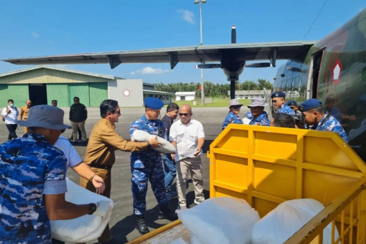 Indonesian Air Force airmen load salt into a NC-212-200 transport aircraft on March 14, 2023, at Raden Sadjad Air Force Base in Ranai, Natuna regency, Riau Islands, during preparation for a cloud seeding flight over Serasan Island.