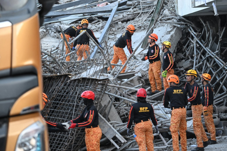 Rescuers clear the rubbles as they continue to search for victims from a collapsed building in Angeles City, Pampanga province, north of Manila on May 24, 2026. Rescuers clawed through the wreckage of a collapsed Philippine building on May 24 which left 23 people missing, with authorities saying that screams were heard from under the rubble.