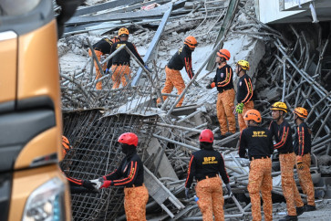 Rescuers clear the rubbles as they continue to search for victims from a collapsed building in Angeles City, Pampanga province, north of Manila on May 24, 2026. Rescuers clawed through the wreckage of a collapsed Philippine building on May 24 which left 23 people missing, with authorities saying that screams were heard from under the rubble.
