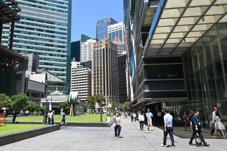 People walk during lunch time at the financial business district of Raffles Place in Singapore on May 19, 2026.