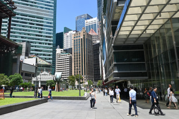 People walk during lunch time at the financial business district of Raffles Place in Singapore on May 19, 2026.