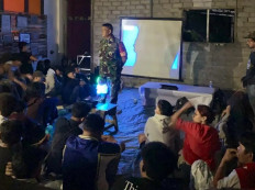 A military officer blocks a projector to shut down a public screening of the documentary Pesta Babi at Khairun University in Ternate, North Maluku, on May 12, 2026. Authorities halted the event under the pretext that it lacked an official permit.