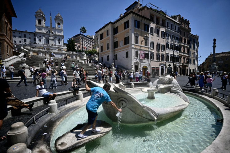 A man fills a bottle of water at the Barcaccia fountain near the Spanish Steps during an early-season heatwave in Rome on May 26, 2026.