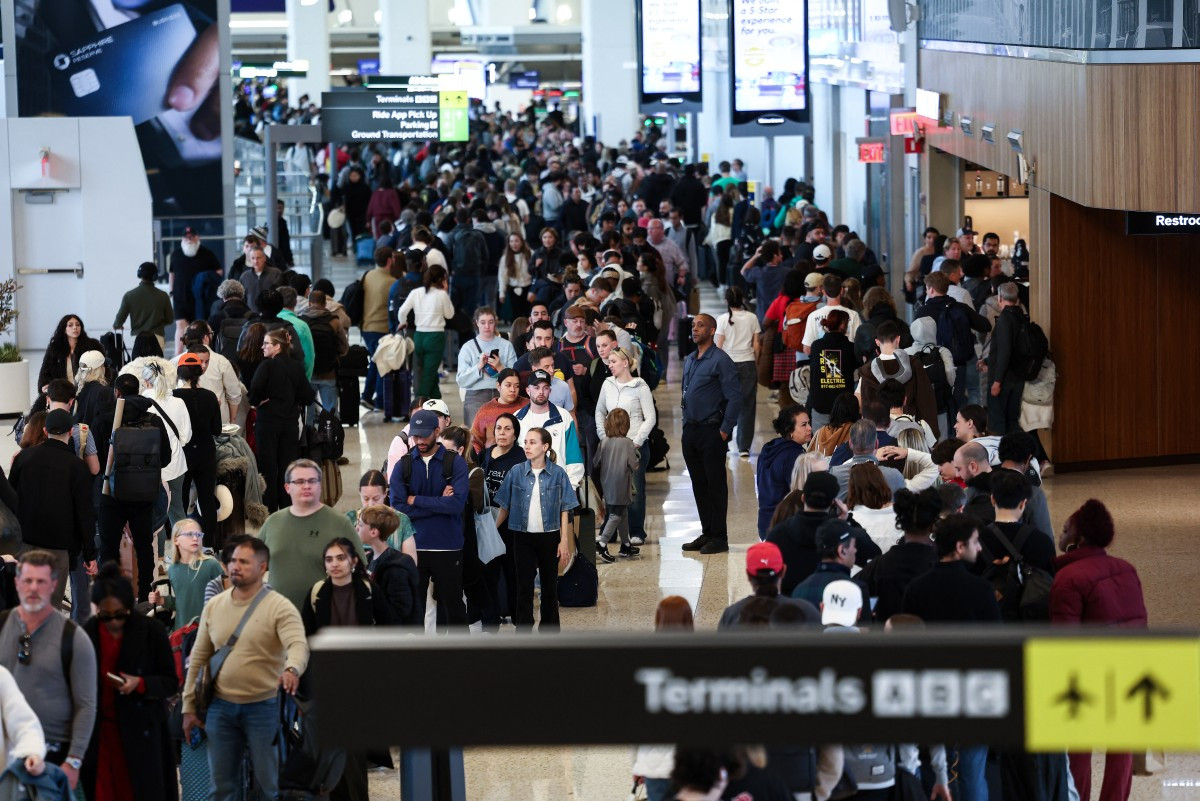 Passengers queue to go through security at New York's LaGuardia airport on March 22, 2026.