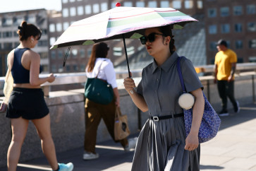 A woman shields herself from the sun as she crosses London Bridge during a heatwave, after the UK recorded its hottest May bank holiday ever, in London, Britain, May 26, 2026.
