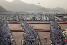 Muslim pilgrims walk on the first day of the stoning of the devil ritual, during the annual haj pilgrimage, in Mina, Saudi Arabia, on May 27, 2026.
