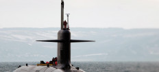 A naval seaman stands watch on a Scorpene submarine as other crew members work on its deck as the vessel surfaces in an undisclosed location, in this undated picture. 