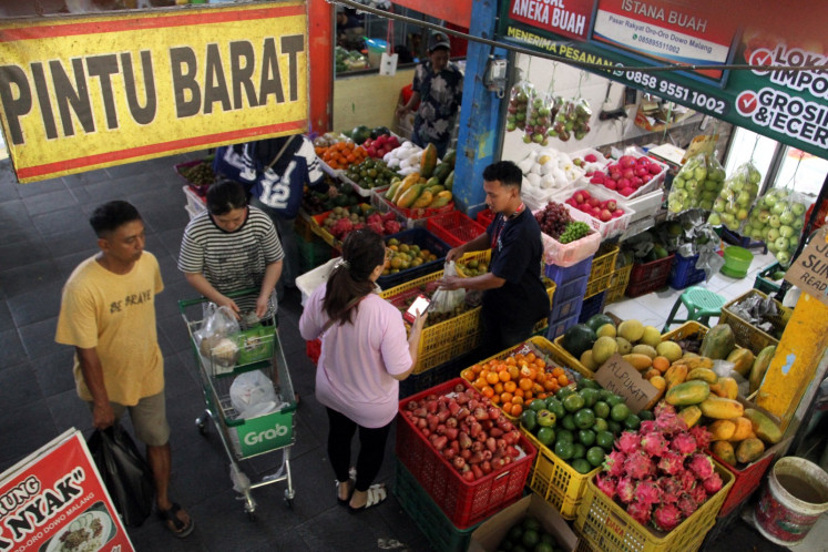 Fruitful transaction: A vendor (right) serves a customer on May 21, 2026 at his stall in the Oro-Oro Dowo traditional market in Malang, East Java.