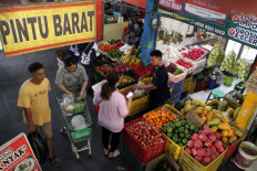 Fruitful transaction: A vendor (right) serves a customer on May 21, 2026 at his stall in the Oro-Oro Dowo traditional market in Malang, East Java.