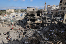 Palestinians inspect the rubble at the site of a residential building targeted overnight by an Israeli strike, following a warning from the Israeli military to evacuate, in Deir el-Balah in the central Gaza Strip, on May 24, 2026.