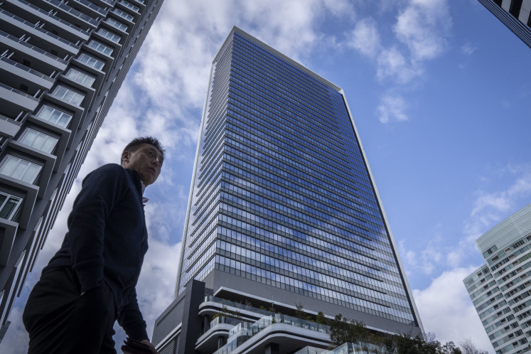 A man walks past Japan's SoftBank Group headquarters building in Tokyo on Feb. 12, 2026.