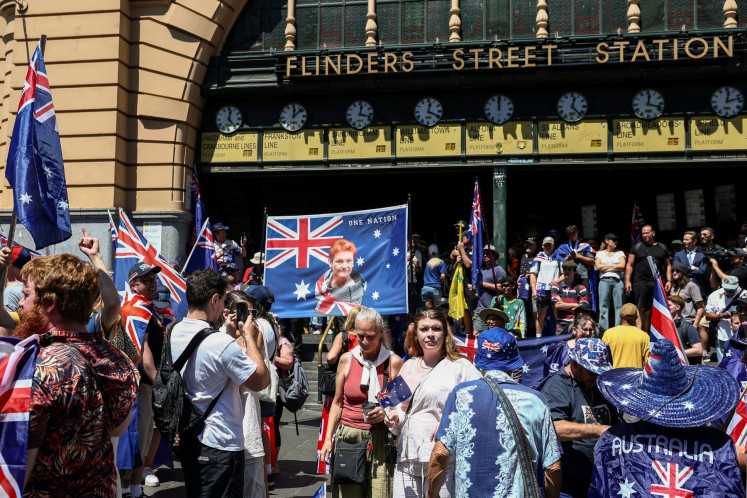 A demonstrator displays a banner showing One Nation Senator Pauline Hanson (center) during an anti-government and anti-immigration protest rally on Australia Day in Melbourne on January 26, 2026. 