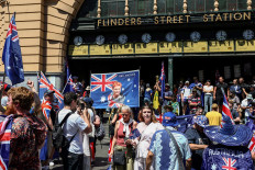 A demonstrator displays a banner showing One Nation Senator Pauline Hanson (center) during an anti-government and anti-immigration protest rally on Australia Day in Melbourne on January 26, 2026. 