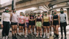 Muting, undone: Yacko (center, front row) stands among 18 other women, their mouths covered with green tape, in a still from the music video for &lsquo;Unbreakable Me&rsquo;, which premiered on YouTube on April 21, 2026, Kartini Day, and is dedicated &ldquo;To all the women who struggle to stay sane every day and heal through running&rdquo;.