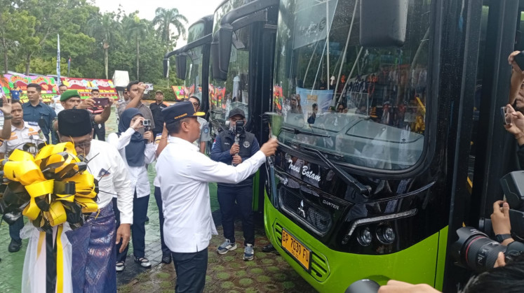 The Transportation Ministry's land transportation director general Aan Suhanan (right) splashes water to officiate 19 new buses for Trans Batam operations at Engku Putri Field in Batam Center in Batam City, Riau Islands, on May 26, 2026. The new buses will be used to serve Hang Nadim International Airport and other busy Trans Batam corridors.