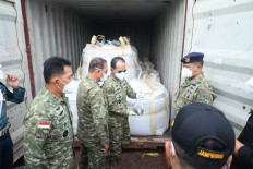 The Indonesian Military (TNI) chief of general staff Lt. Gen. Richard Taruli H. Tampubolon (second right) holds a sack of mineral black sand on May 26, 2026, while the Republic of Indonesia Fleet Command (Koarmada RI) Vice Adm. Denih Hendrata (second left) looks on at the Indonesian Navy&rsquo;s Naval Command (Kodaeral) IV/Batam headquarters&rsquo; pier in Batam, Riau Islands. The Indonesian Navy intercepted a tugboat and a barge carrying 25 containers of some 390 tonnes of raw minerals containing illegal rare earth metals and radioactive elements in Riau Islands waters on May 17, 2026. 