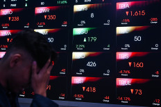A man walks past a digital display on June 3, 2026, showing the movement of the Indonesia Composite Stock Price Index (IHSG) at the Indonesia Stock Exchange in South Jakarta. 