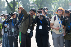 Peeking birds: A guide points while participants look for a bird during a birdwatching activity held by conservation group Burung Indonesia at the Bogor Agricultural University (IPB) in Bogor, West Java on Sept. 20, 2025. Weekend Birding is one of regular programs held by the group to engage the public to be involved in citizen science by observing and documenting various species of birds.