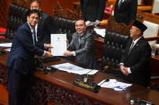 Finance Minister Purbaya Yudhi Sadewa (left) hands over a document containing the government's final statement to Deputy House Speaker Sufmi Dasco Ahmad on June 4, 2026, during a plenary session at the legislative complex in Jakarta.