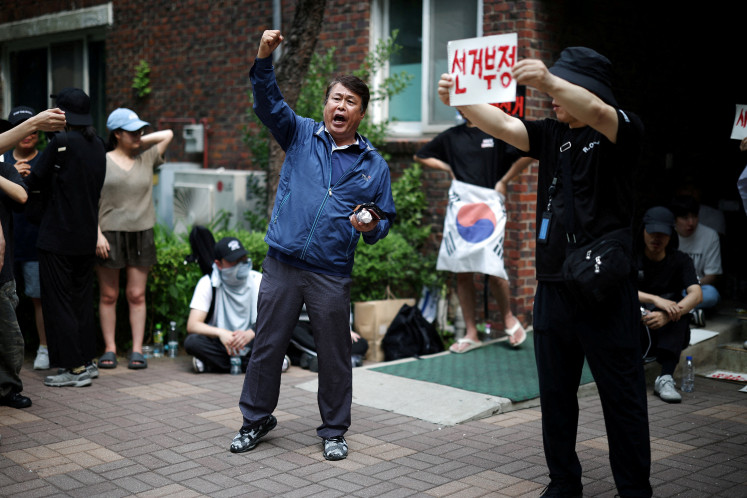 Far-right protesters chant slogans, calling for a halt to vote counting and a rerun of the race, as they surround a polling station where ballot boxes for local elections are still kept in, in Seoul, South Korea, June 4, 2026. 