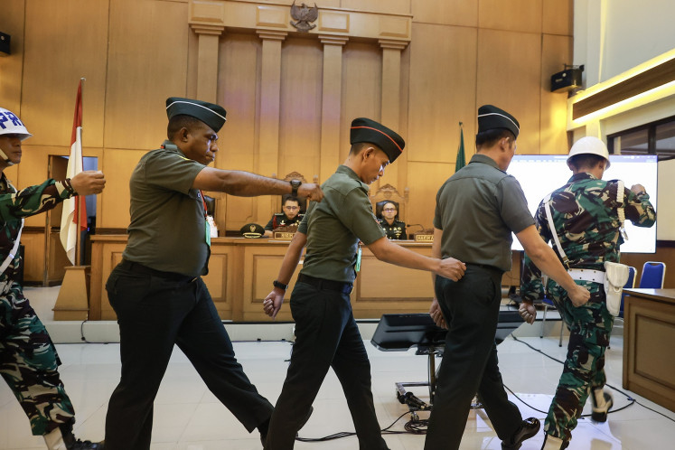 Defendants in a murder case of a bank branch head in Jakarta, Chief Sgt. Frengky Yaru (second left), Second Cpl. Feri Heriyanto (center) and Chief Sgt. Mochamad Nasir, are escorted out of the courtroom after their verdict hearing at the Jakarta Military Court in Jakarta on June 3, 2026. The judges sentenced Nasir to 13 years in prison, Feri to seven years and Frengky to a year after finding them guilty in the murder case.