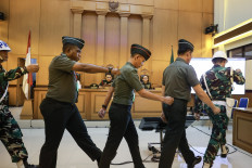 Defendants in a murder case of a bank branch head in Jakarta, Chief Sgt. Frengky Yaru (second left), Second Cpl. Feri Heriyanto (center) and Chief Sgt. Mochamad Nasir, are escorted out of the courtroom after their verdict hearing at the Jakarta Military Court in Jakarta on June 3, 2026. The judges sentenced Nasir to 13 years in prison, Feri to seven years and Frengky to a year after finding them guilty in the murder case.
