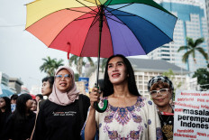 Echa Wa&rsquo;ode (center), an activist from LGBTQ rights organization Arus Pelangi, marches with other participants on March 8, 2025, during a protest organized by the Indonesian Women's Alliance (API) on the 50th International Women's Day demanding labor rights, gender equality and protections in Jakarta.