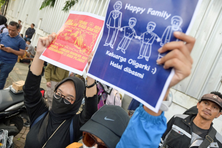 Protesters hold posters, one of which reading &ldquo;Oligarchic families should be eradicated', during a rally in front of the General Election Commission (KPU) building in Jakarta on Aug. 23, 2024.