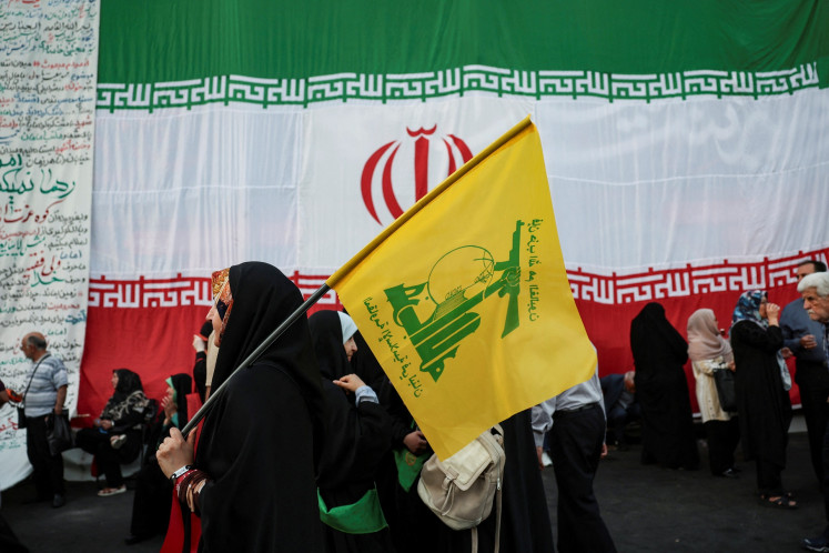 A woman holds a Hezbollah flag during a rally in support of Iran's Supreme Leader Mojtaba Khamenei in Tehran, Iran, on June 4, 2026.