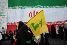 A woman holds a Hezbollah flag during a rally in support of Iran's Supreme Leader Mojtaba Khamenei in Tehran, Iran, on June 4, 2026.