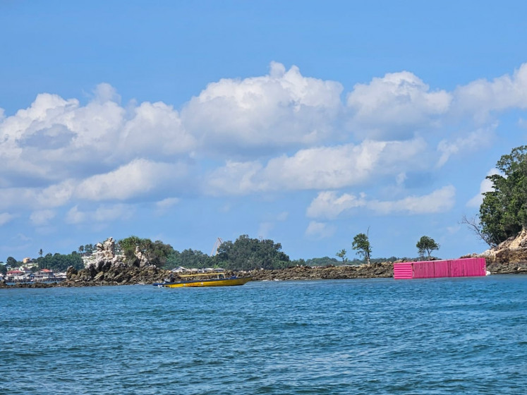 A container (right) is seen ashore on June 6, 2026, on Sambu Kecil Island, northwest of Batam Island, Riau Islands, after falling from a container vessel which sunk in Singapore Strait. The Tanzanian-flagged MV Golden Star I sunk after reporting severe leakage on the evening of June 5, 2026, and the 107 containers it carried were thrown into the open sea.