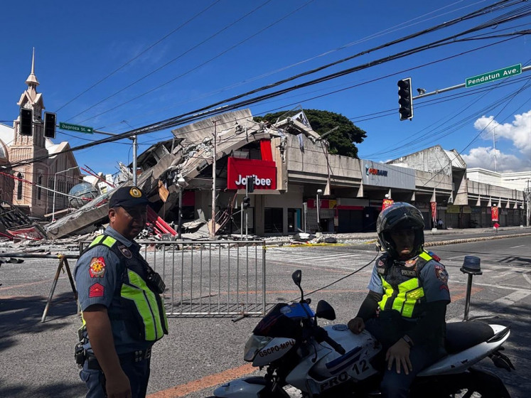 Police gather in front of a collapsed Jollibee fast food restaurant after an 7.8 magnitude earthquake in General Santos City, Philippines, on June 8, 2026. A 7.8-magnitude earthquake that struck the southern Philippines on June 8 killed at least one person and collapsed buildings, police said, as the disaster sparked tsunami warnings across the region.