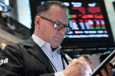 A trader looks at a tablet on the floor of the New York Stock Exchange during morning trading on June 4, 2026 in New York City, the United States. 