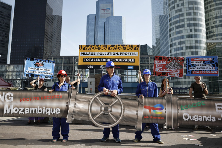 People take part in a protest organized by associations Attac, Avaaz, 350 and Action Justice Climat Paris, with TotalEnergies's headquarters tower in the background on the sidelines of its annual general meeting, to denounce &ldquo;the financial and political support the group continues to receive, despite its ongoing fossil fuel projects and their human, climate and environmental impacts&ldquo;, in the forecourt of La Defense business district in Puteaux, France, on May 29, 2026.