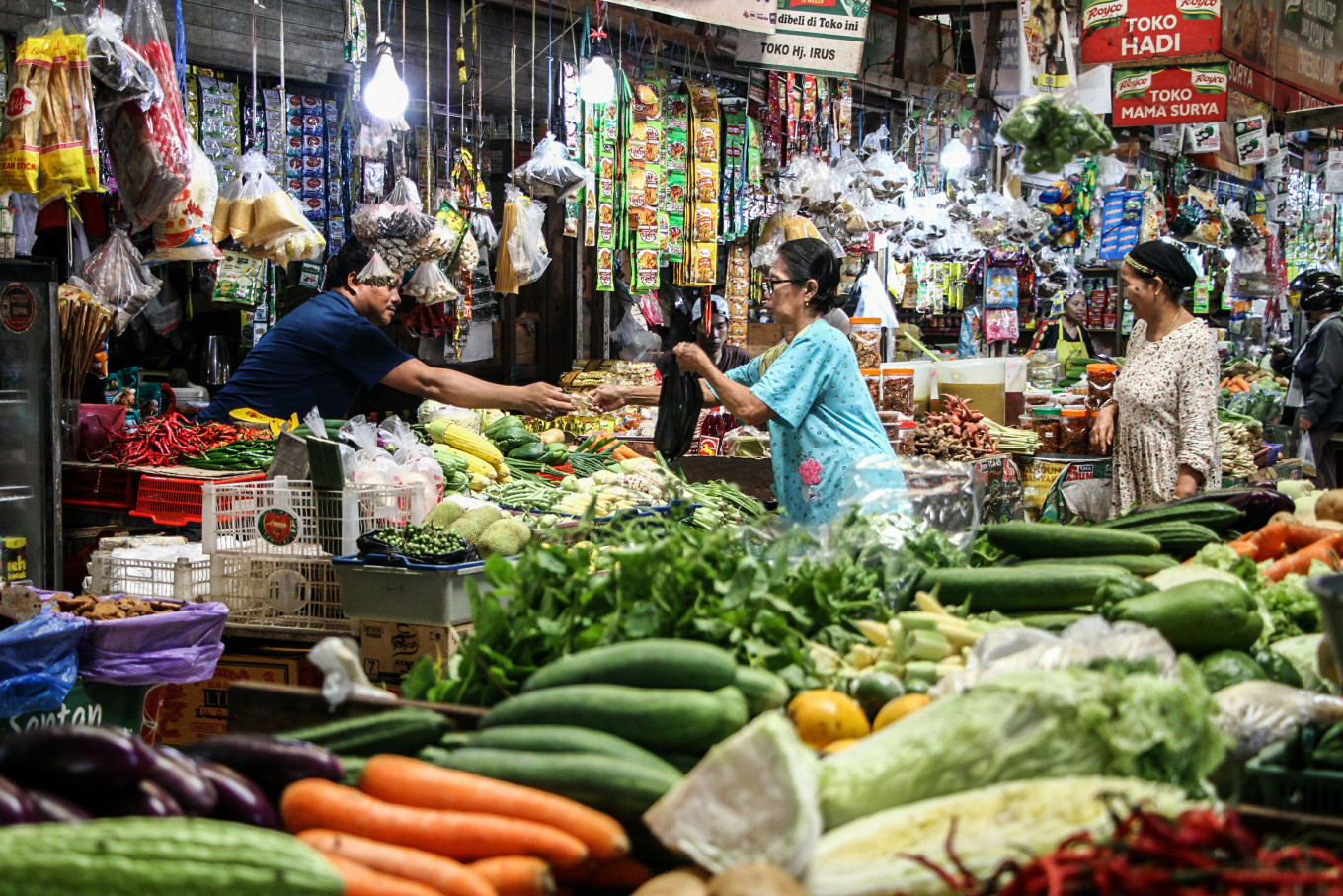 A vendor serves customers shopping for staple foods on June 11 at Kahayan Market in Palangka Raya, Central Kalimantan.