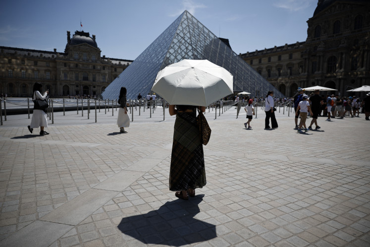 A person protects from the sun under an umbrella in front of the Louvre museum in Paris as a record-breaking early heatwave scorches a swathe of western Europe on May 28, 2026. The UK and France have reported their hottest ever May days this week as a &ldquo;heat dome&ldquo; brought sizzling temperatures more typical of midsummer to western Europe. UN climate chief Simon Stiell said the heatwave was &ldquo;a brutal reminder of the spiraling impacts of the climate crisis. &ldquo;The science is clear that human-induced climate change is making these heatwaves more frequent and extreme,&ldquo; Stiell add in a statement. 