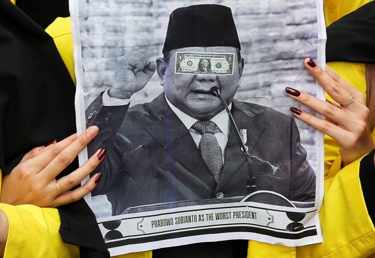 A student holds a poster depicting President Prabowo Subianto during a protest against government policies, including state budget spending, fuel price hikes, the free meals program and expanded military roles in civilian affairs, on June 12 in Jakarta.
